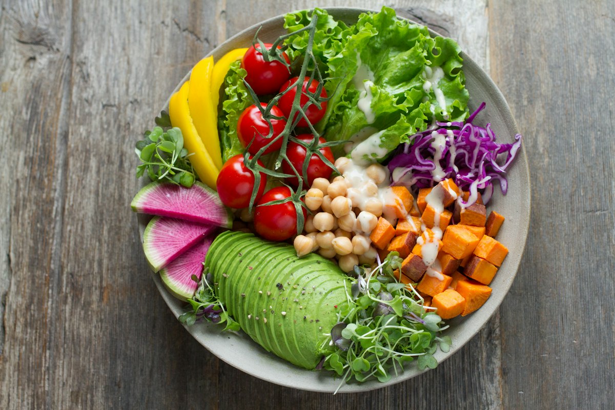 Person preparing a balanced meal with vegetables and whole grains